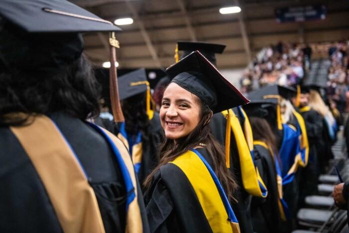 Graduate student smiling at the camera during graduation.